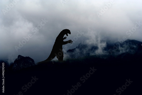 Silhouette eines grauenhaften, Godzilla-artigen Monsters auf einem Berg
