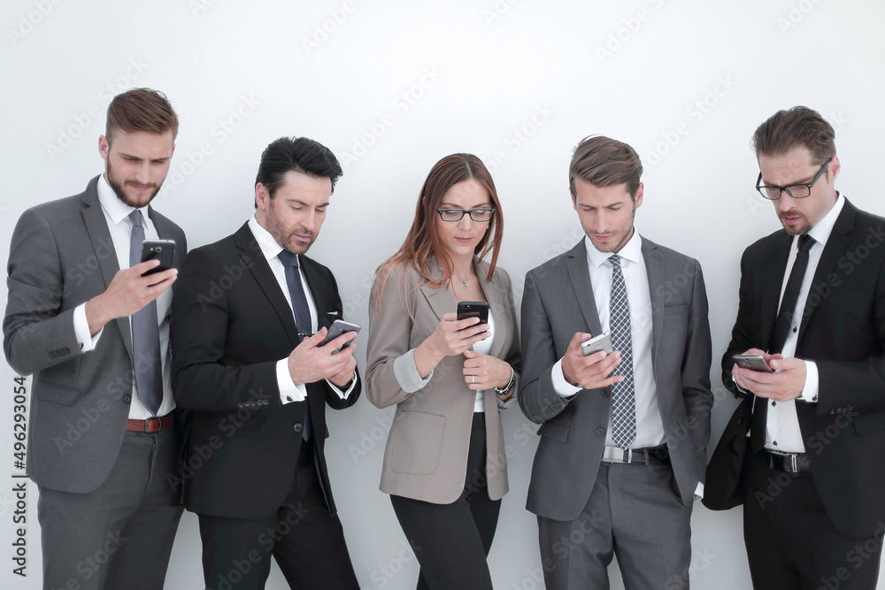 group of business people looking at the screens of their smartphones group of business people looking at the screens of their smartphones