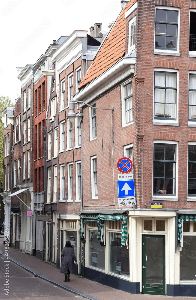 Amsterdam Oude Spiegelstraat Street View with Brick House Facades and Walking Woman, Netherlands