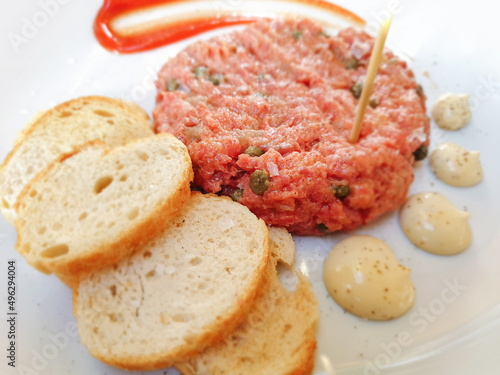 Obraz na plátne Steak tartare I tartar made of raw ground minced beef served with sauce and bread in restaurant