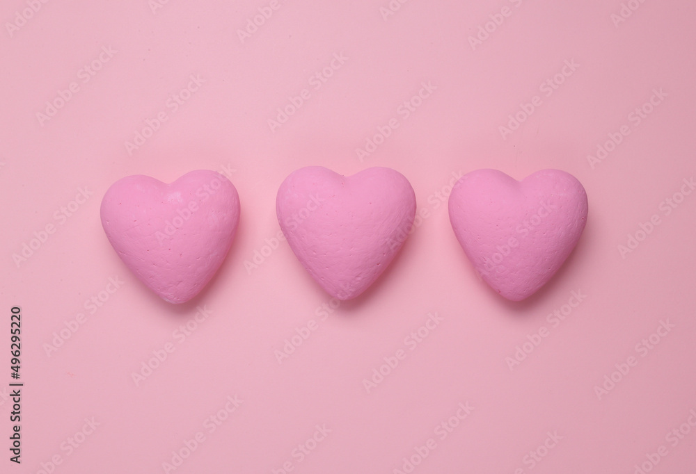 Three pink hearts on a pink background. Minimal love still life
