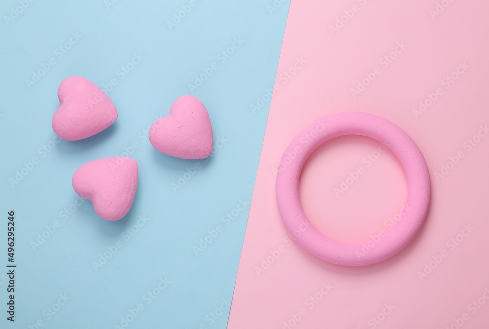 Pink ring and hearts on pink blue background. Love concept. Top view Pink ring and hearts on pink blue background. Love concept. Top view