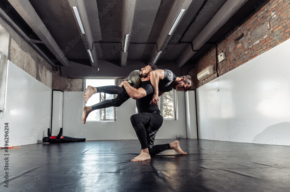 Fototapeta premium Sparring training of two athletic mma fighters in the gym. Martial arts, Wrestling