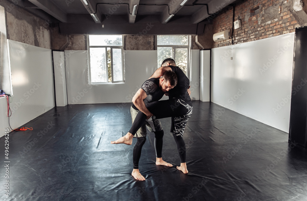 Sparring training of two athletic mma fighters in the gym. Martial arts