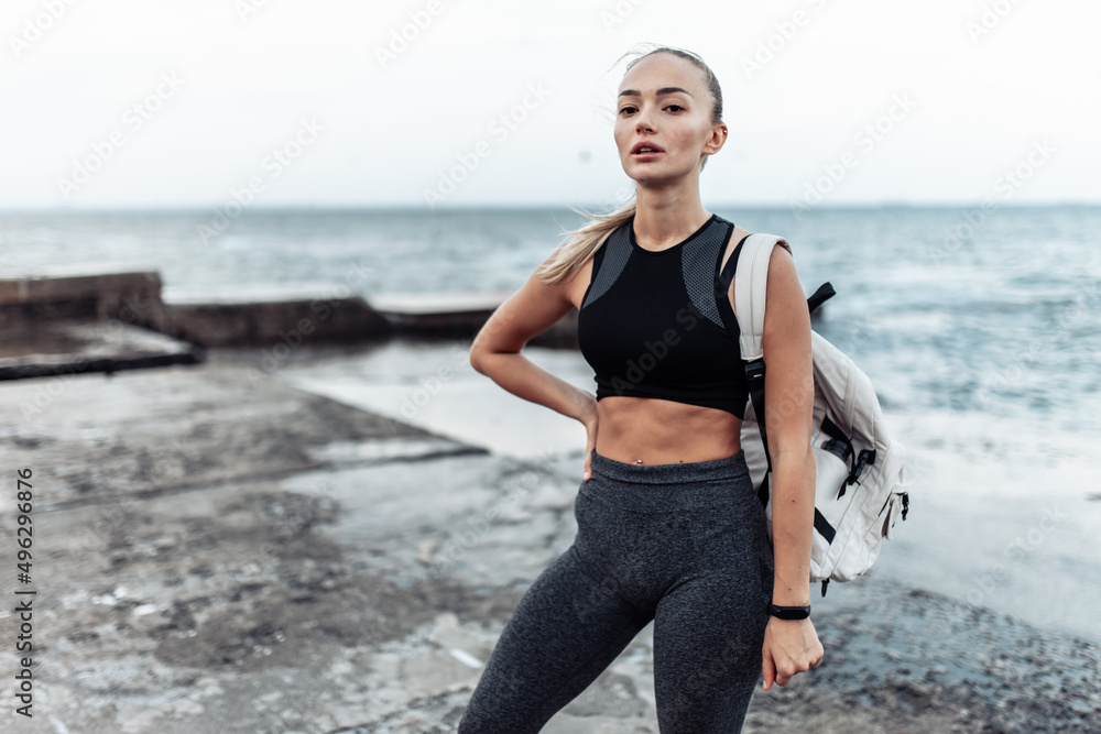 Portrait of young fit woman in sportswear on urban beach Portrait of young fit woman in sportswear on urban beach