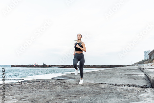 Young fit woman jogging on urban beach