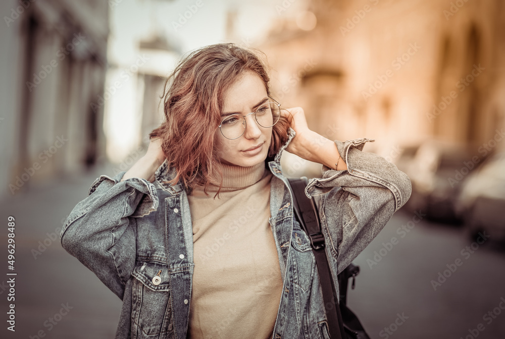 Fototapeta premium Stylish attractive woman in denim jacket on urban street