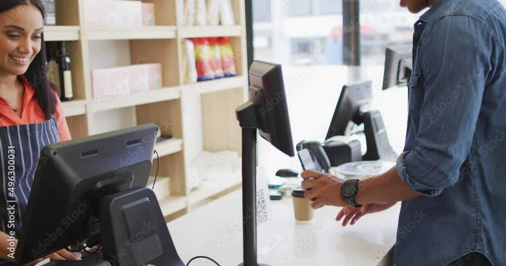 Video of happy biracial man paying with smartphone for coffee to biracial waitress Video of happy biracial man paying with smartphone for coffee to biracial waitress