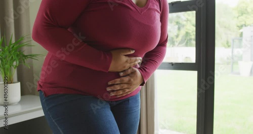 Video of midsection of plus size african american woman having stomach ache