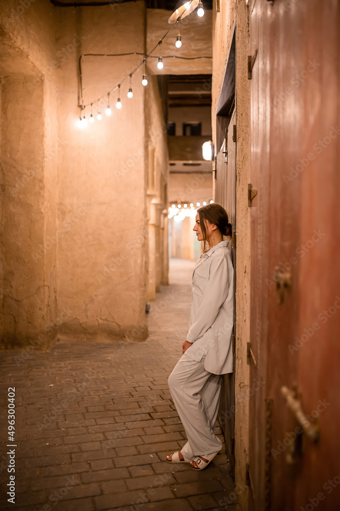 Woman tourist walking in Al Seef Meraas Dubai - old historical district with traditional Arabic architecture