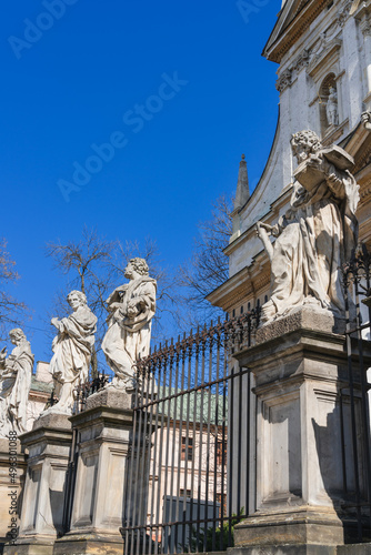 Statues of the apostles of the Church of Saints Peter and Paul in Krakow in early spring against the blue sky in spring. Vertical orientation, side view