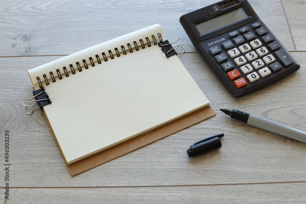 Blank notepad with calculator on wooden table Blank notepad with calculator on wooden table
