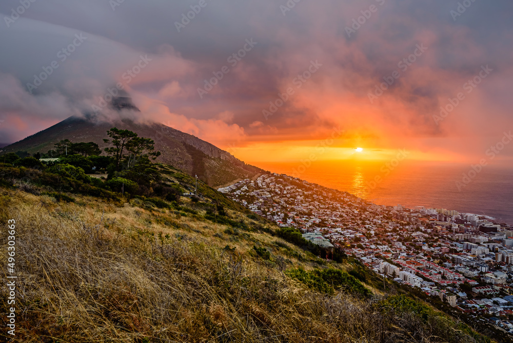 Fototapeta premium A dramatic sunset over Cape Town with the Lion's Head summit in clouds.