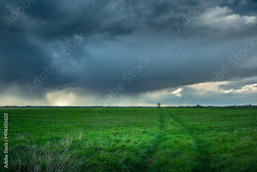 The road through the meadow and the rainy dark cloud  Czulczyce  Poland