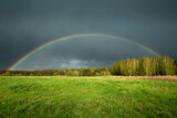 View of a rainbow with a rainy dark cloud, Czulczyce, Poland