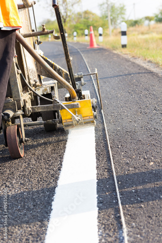 Machine eject and worker on road and traffic sign painting