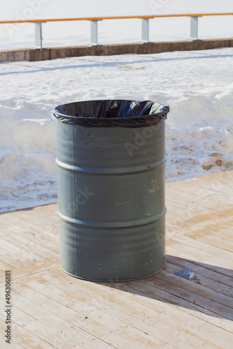 Garbage can in a metal barrel outside