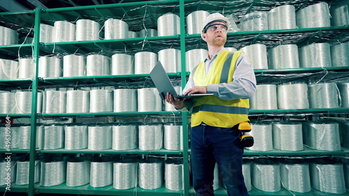 Male worker is doing inventory of fiberglass in the storage