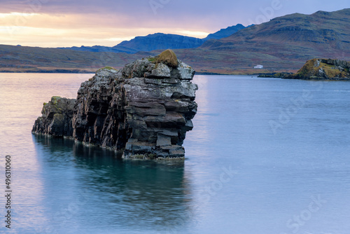 A lion shaped basalt rock sits in the water in the East Fjord region of Iceland. photo