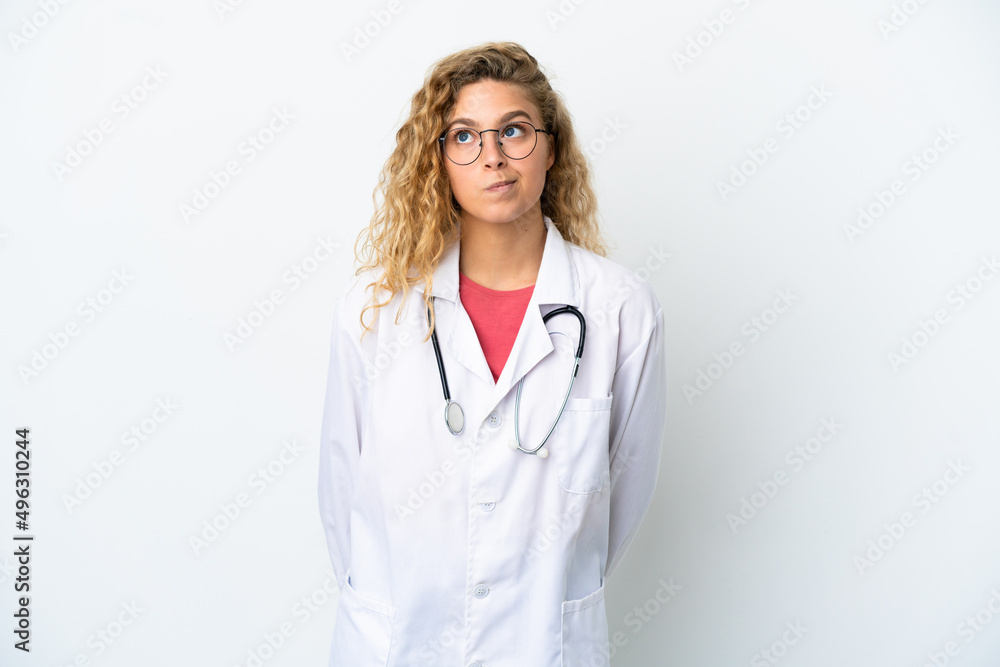 Fototapeta premium Young doctor blonde woman isolated on white background and looking up