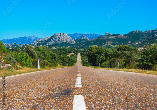 Asphalt road and white stripe. The strip on the asphalt is directed forward. Provincial road near Aggius, Sardinia - Italy photo