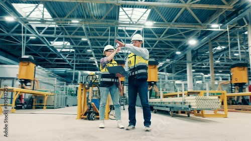 Fiberglass factory with two specialists making plans