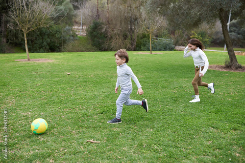 boy and girl playing football in a park