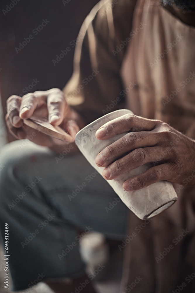 the artist polishing rough edges of a ceramic pot with a sponge