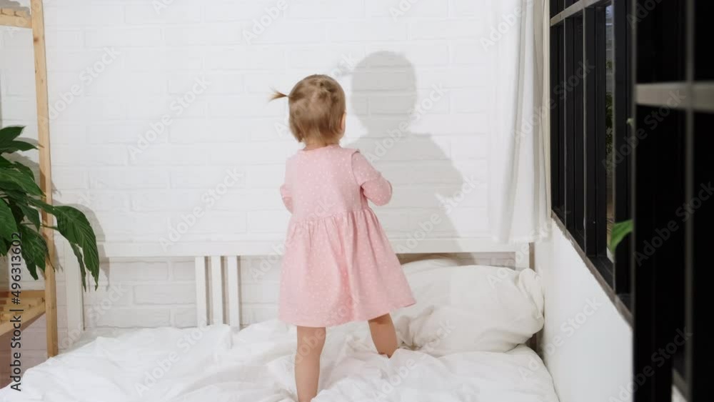 Happy child girl having fun jumping and playing funny active game in parents bed, Bouncing, fooling around, frolics , laughing at home Happy child girl having fun jumping and playing funny active game in parents bed, Bouncing, fooling around, frolics , laughing at home