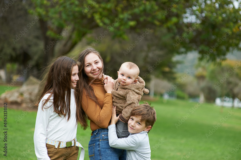 mother with children on a walk in the park together mother with children on a walk in the park together