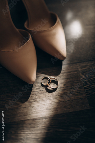 Bridal accessories. Women's leather shoes and wedding rings. morning of the bride. selective focus. black and white photo