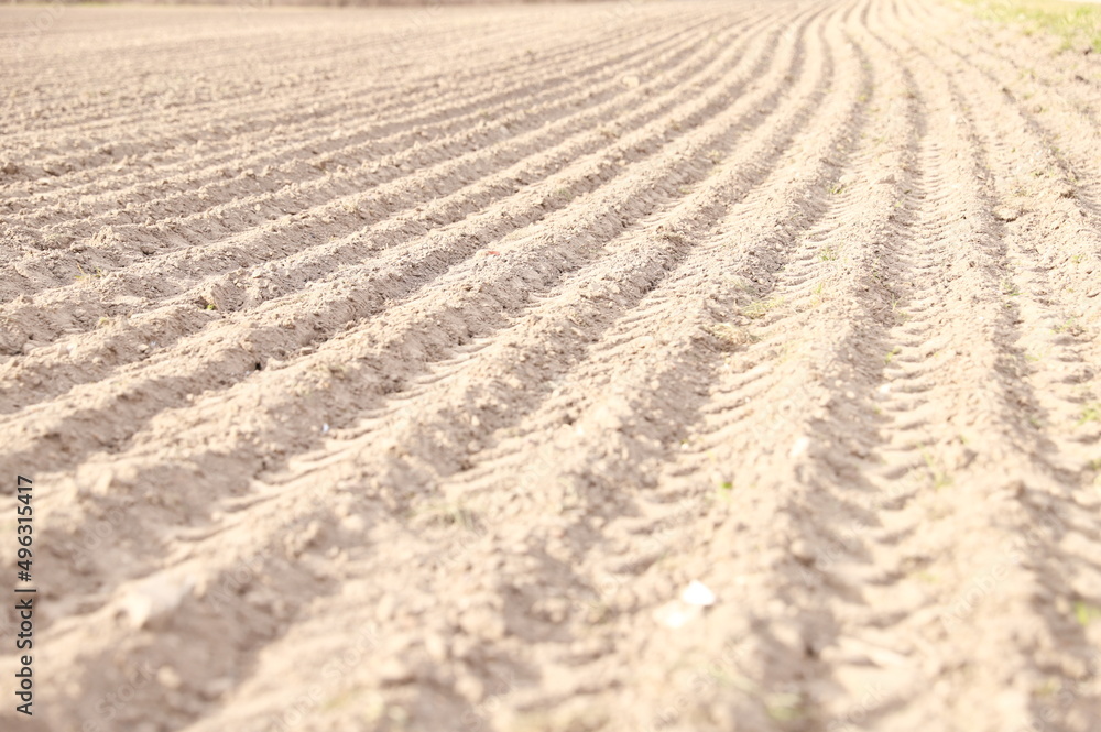 Stripes on the ground on the field from tractor wheels, agriculture, plowed field, furrows on dry land. Stripes on the ground on the field from tractor wheels, agriculture, plowed field, furrows on dry land.