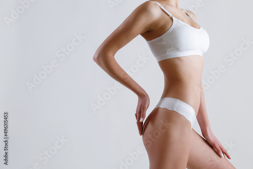 Close up shot of unrecognizable fit woman in lingerie isolated on white background. Cropped shot of lower half of slim attractive female's body in white underwear. Copy space for text.
