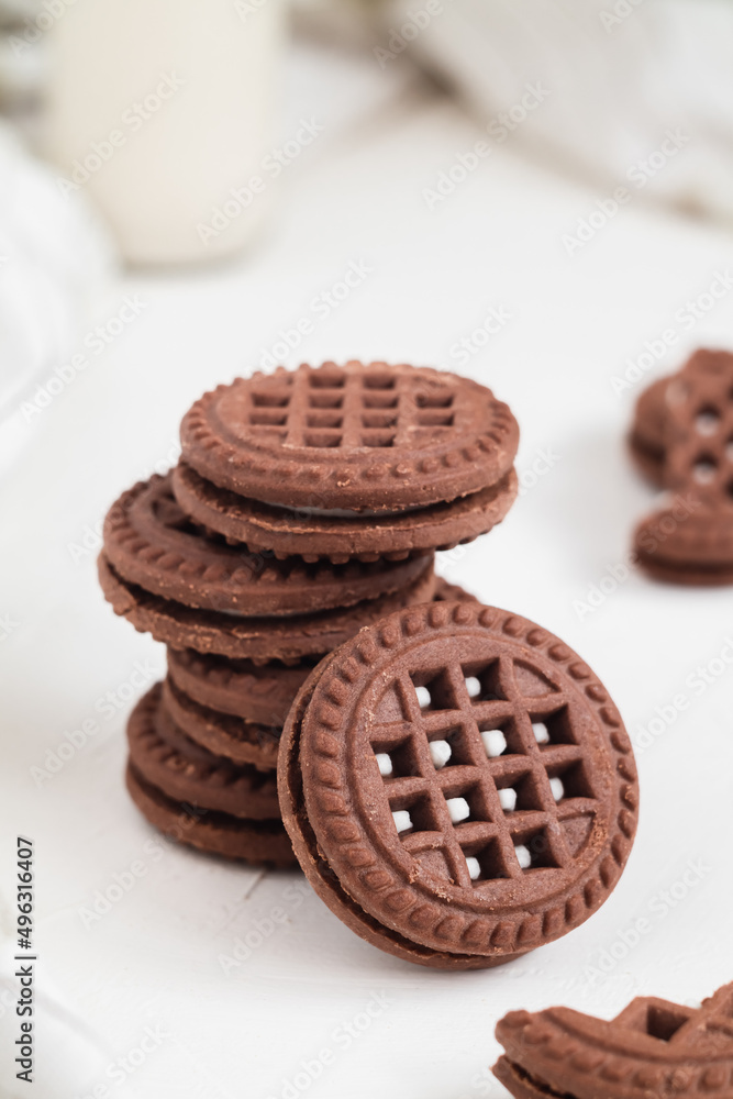 Sweet chocolate sandwich cookies close up with cream fiiling on a white table. Sweet chocolate sandwich cookies close up with cream fiiling on a white table.