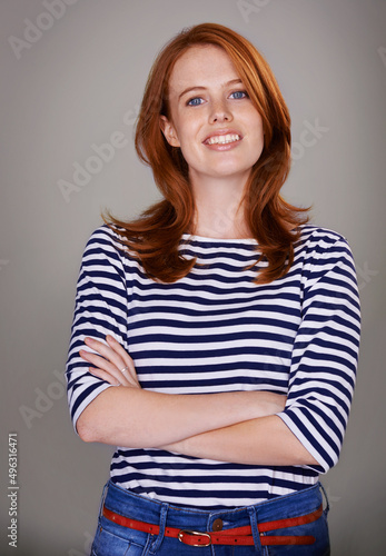 Shes bubbly and confident. Studio portrait of an attractive woman against a gray background.