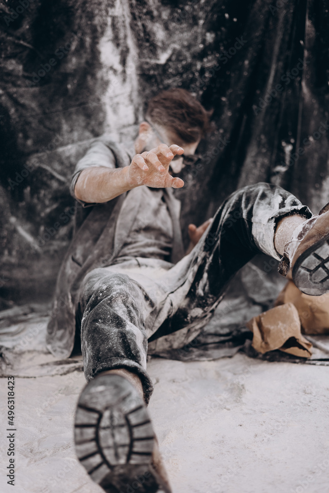 selective focus, noise effect: stylish portrait of a young bearded man in black clothes on a black background. The man is strewn with white matter