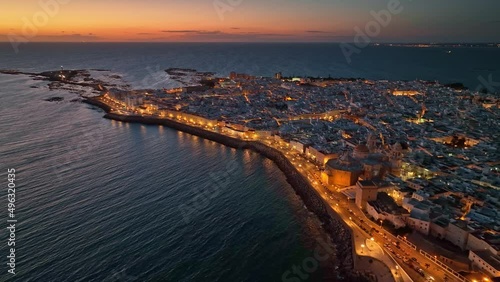 Sunset view of Cadiz, Andalusia, Spain with citylights. Great aerial view of evening Cadiz and Catedral de Santa Cruz de Cadiz photo