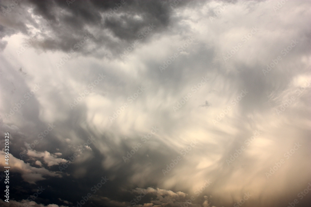 Summer evening sky. On a water color cloudy background in gray tones there are small light clouds. Abstract picture.