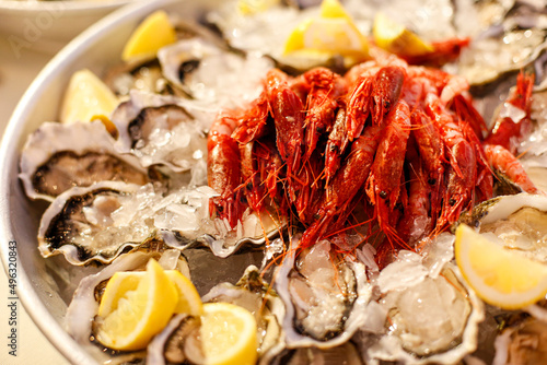 Tableau sur toile pesce servito a crudo come gamberi e ostriche in una tavola imbandita
