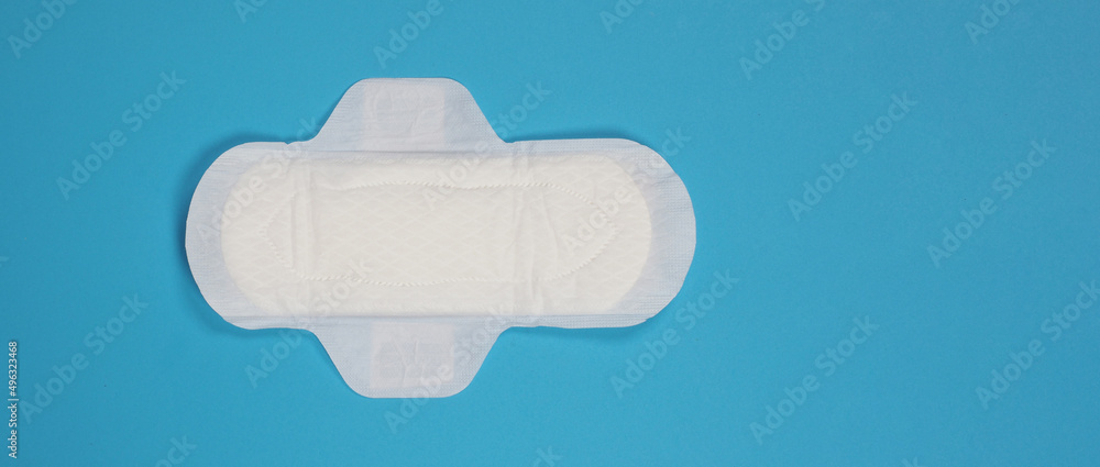 Woman sanitary napkins on blue background. Top view. Absorbent pads worn by women to absorb menstrual blood. Comfortable white sanitary napkins arranged on light blue paper. Represent Hygiene concept - obrazy, fototapety, plakaty 