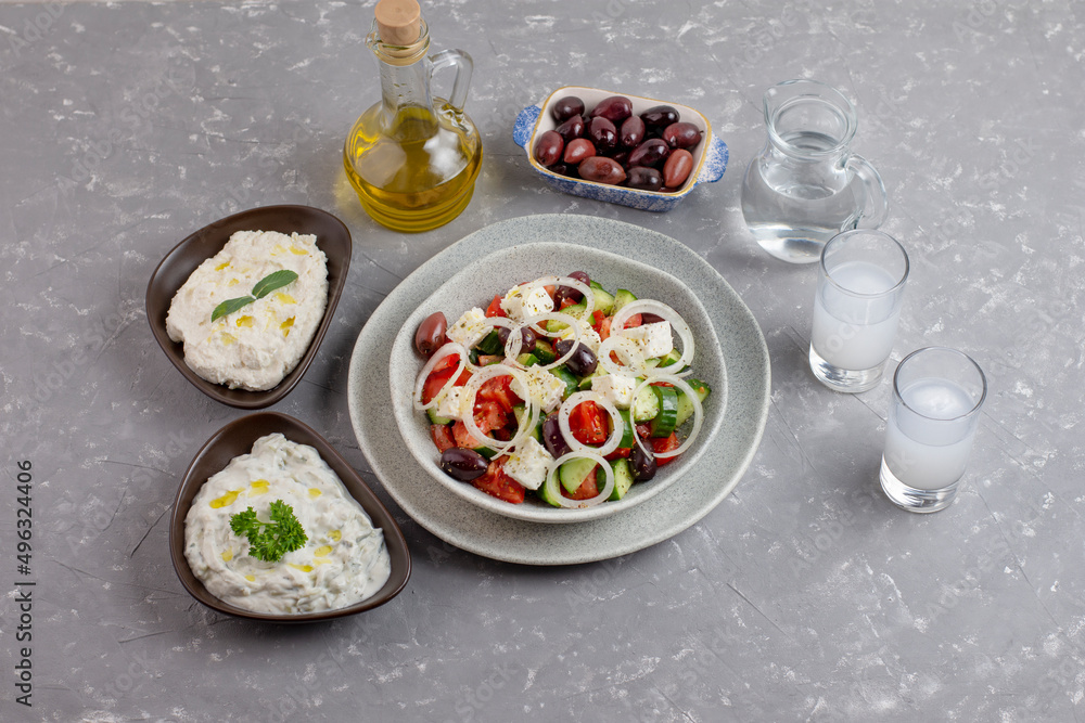 Greek salad with tzatziki, olives and feta cream. Traditional salad, meze,  with olive oil. Ouzo or Raki and traditional greek salad, tzatziki and olives