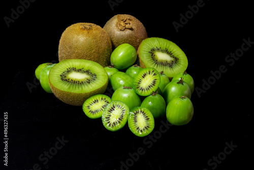 Detail of kiwis of different varieties, Green Kiwi and Baby Kiwi with black background