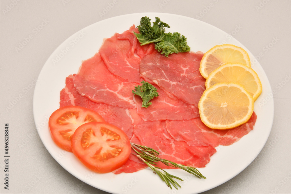 Carpaccio dish of thinly sliced pieces (slices) raw beef tenderloin Carpaccio dish of thinly sliced pieces (slices) raw beef tenderloin