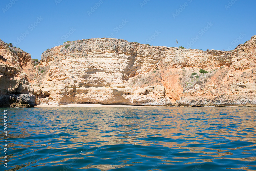 Arrival by boat to a beautiful empty beach in Algarve, Portugal. Impressive sandstone cliffs.