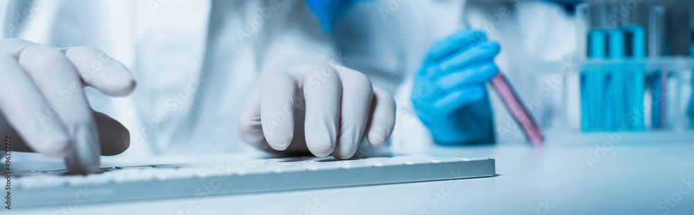 partial view of scientist in latex gloves typing on computer keyboard, banner.