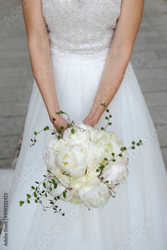 dettaglio del bouquet di fiori  bianchi tenuto in mano da una sposa  photo