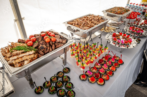 Banquet table with chafing dish heaters. Grilled meat photo