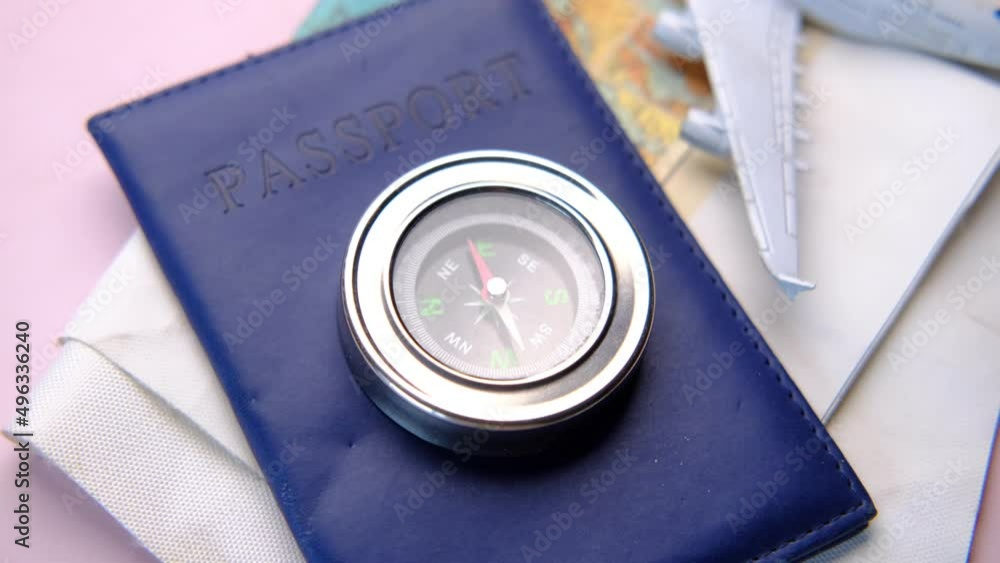 a passport, compus with travel map on table,