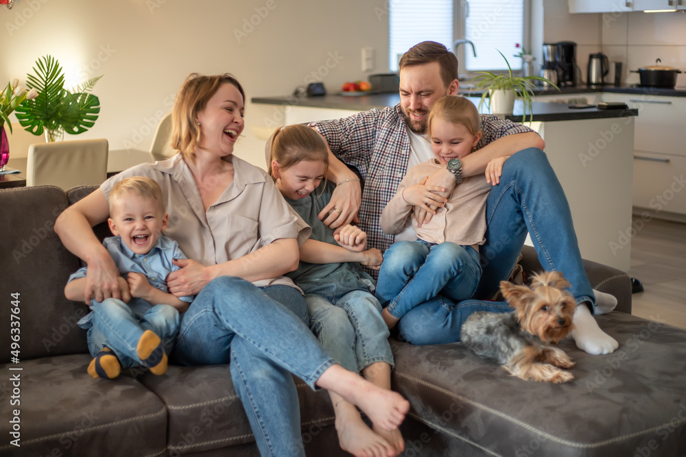 family portrait. family photo in which mom, dad, daughters, son and dog are smiling and hugging on the couch in a cozy homely atmosphere family portrait. family photo in which mom, dad, daughters, son and dog are smiling and hugging on the couch in a cozy homely atmosphere