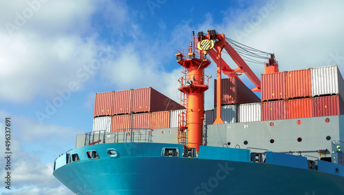 Front view of large blue container cargo ship. Performing cargo export and import operation.